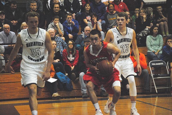 Spencer's Bobby Pilz drives past Columbus Catholic's Tyler Fuerlinger, left, and Evan Nikolai during the second half of the Rockets' loss at Columbus Catholic High School on Monday. (Photo by Paul Lecker/MarshfieldAreaSports.com)
