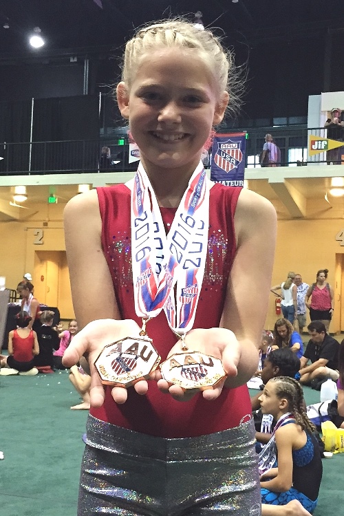 Marshfield MAGIC gymnast Kayla Drexler proudly displays two medals she won at the AAU National Gymnastics Tournament at Disney World in Orlando, Fla., on July 1-2. (Photo submitted by Allie Dryer)