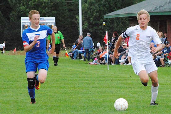 Marshfield’s Alec Hinson, right, outruns Merrill’s Austin Burgener for the ball during the Tigers’ 10-3 win on Tuesday at Griese Park. (Photo by Paul Lecker/MarshfieldAreaSports.com)